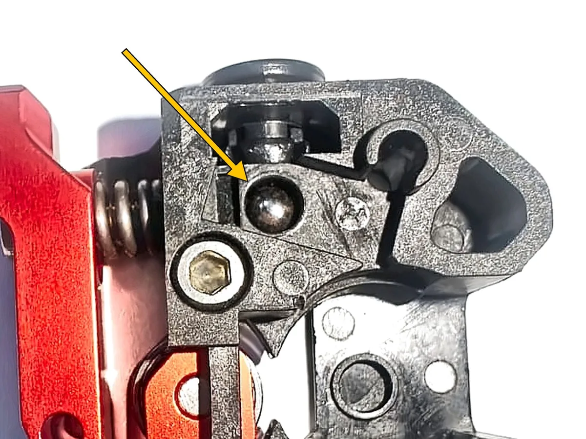 Step 10, inserting the trigger ball: Drop the 4 mm steel ball (J) into its pocket in the front body.